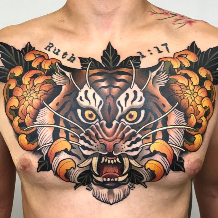 a man with tattoos on his chest and chest is wearing a tiger head tattoo design