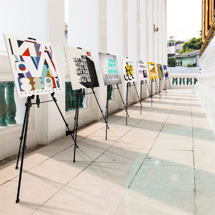 a row of easels sitting on the side of a building next to each other