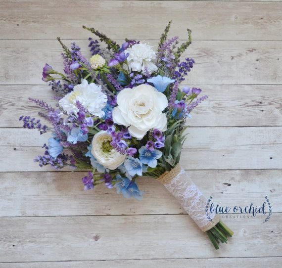 a bouquet of white and blue flowers on a wooden surface