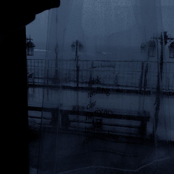 a bench sitting in front of a window on a rainy day