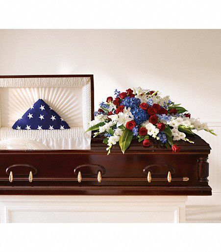 a casket with flowers and an american flag pillow