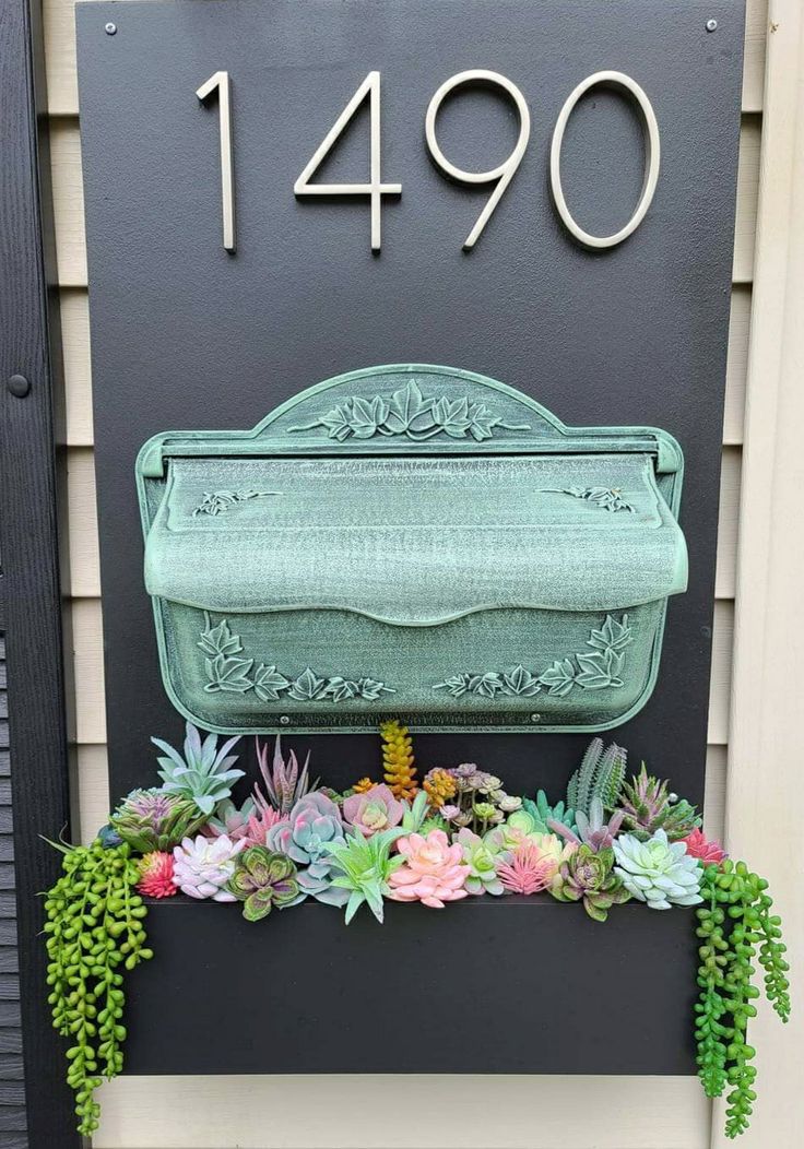 a green mailbox with succulents in front of it and the number 9490