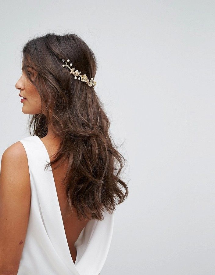 a woman wearing a white dress with a gold headpiece on her head and long hair