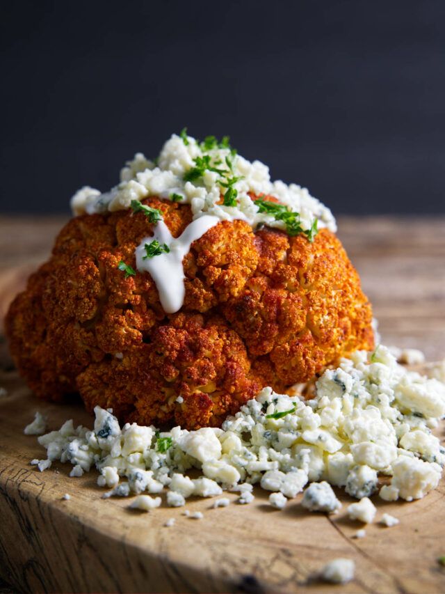 a close up of food on a cutting board with feta cheese and parsley