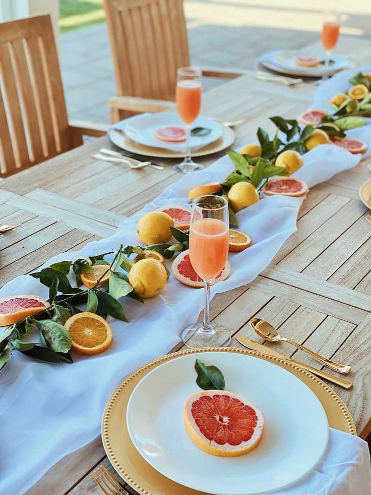 the table is set with grapefruit, oranges and watermelon slices