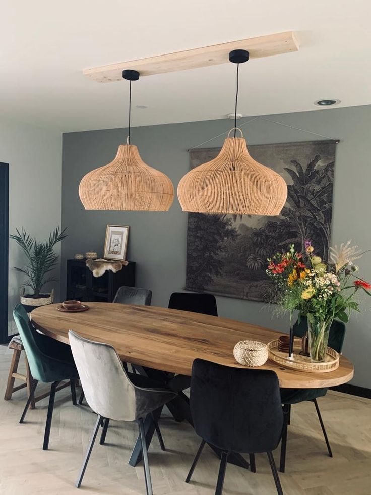 a dining room table with chairs and lights hanging from it's ceiling over it