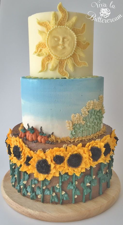 a three tiered cake decorated with sunflowers and other decorative items on a wooden stand