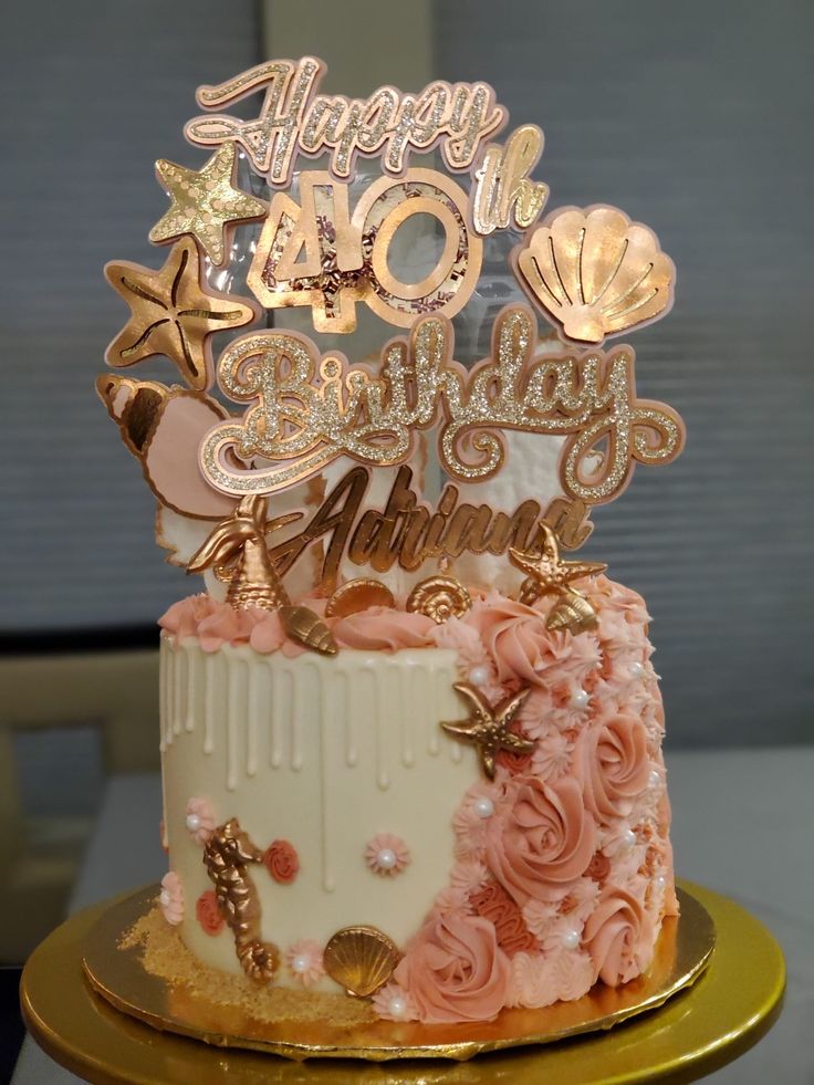 a birthday cake decorated with pink and gold decorations