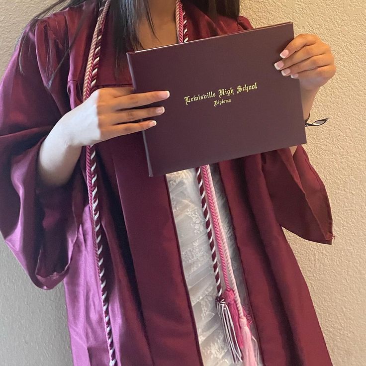 a woman in a purple graduation gown holding up a sign that says, congratulations may be heard