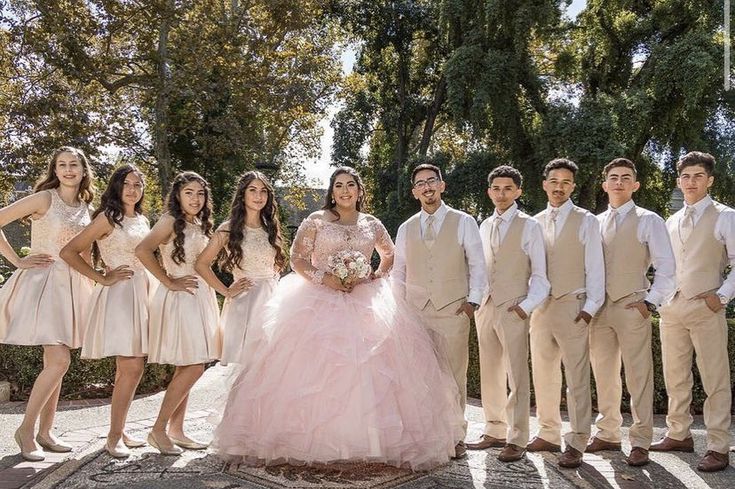 a group of young people standing next to each other in formal wear and tuxedos