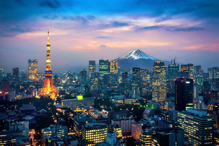 the tokyo skyline at night with mt fuji in the background