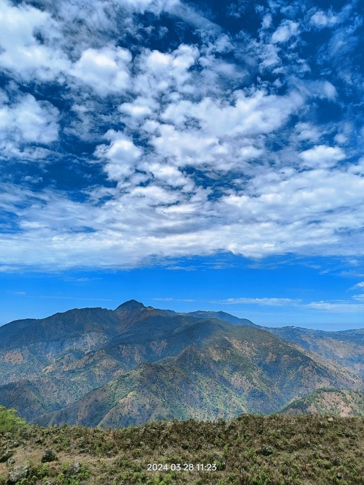 the mountains are covered in clouds and blue sky