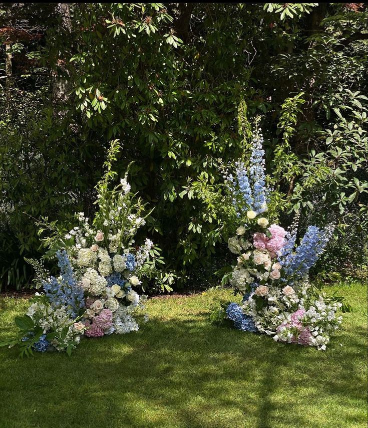 three vases filled with flowers sitting in the grass