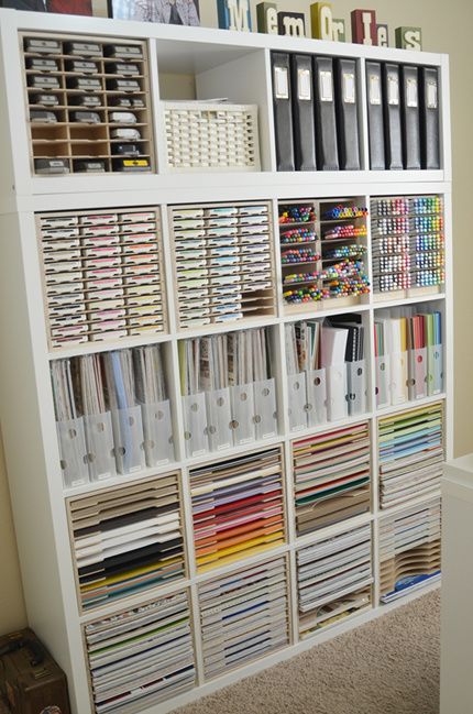 a white bookcase filled with lots of books and binders on top of it