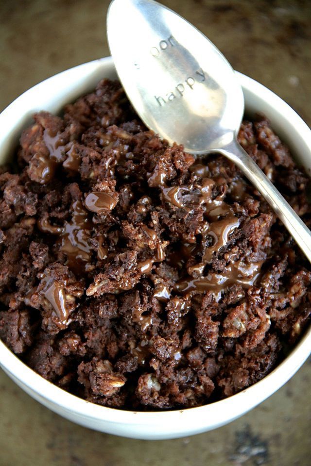 a white bowl filled with chocolate pudding and a spoon