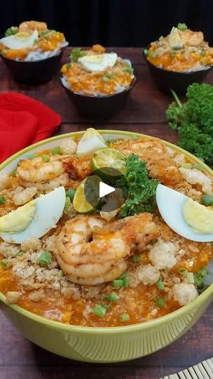 a bowl filled with shrimp and rice on top of a wooden table