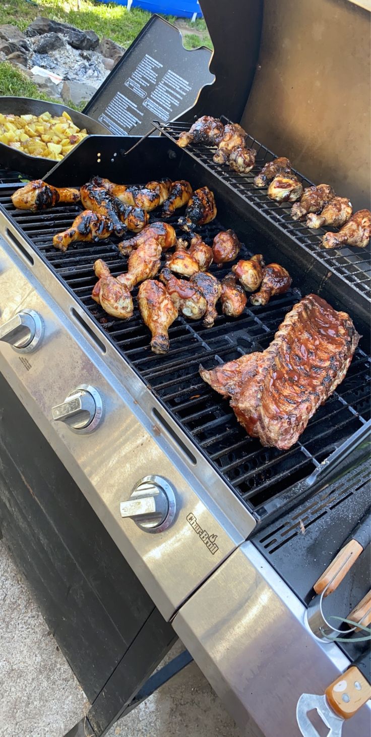 the grill is full of different types of meats and vegetables on it's side