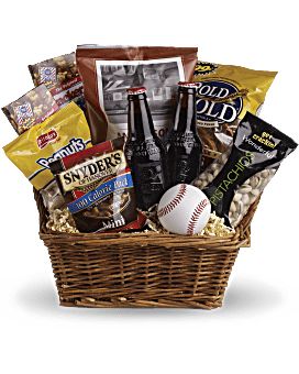 a basket filled with snacks and beer next to a stuffed baseball on top of a table