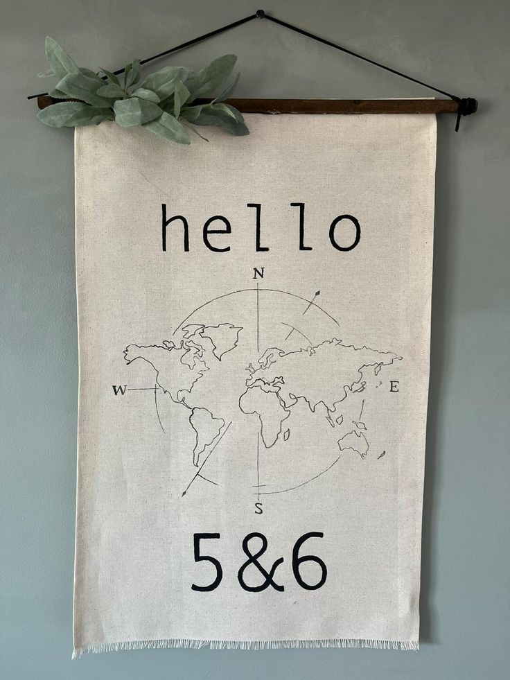 a banner hanging on the wall that says hello and has a world map drawn on it