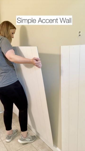 a woman standing next to a wall with a white panel on it's side