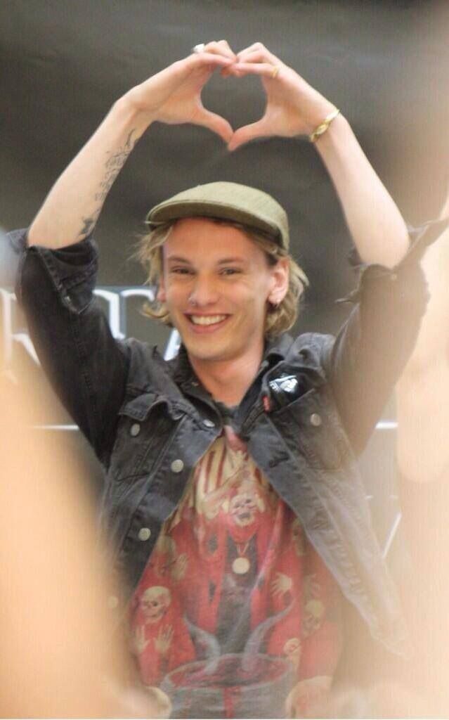 a man making a heart shape with his hands