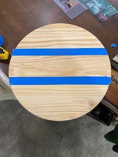 a wooden table with blue tape on it in the middle of a living room area