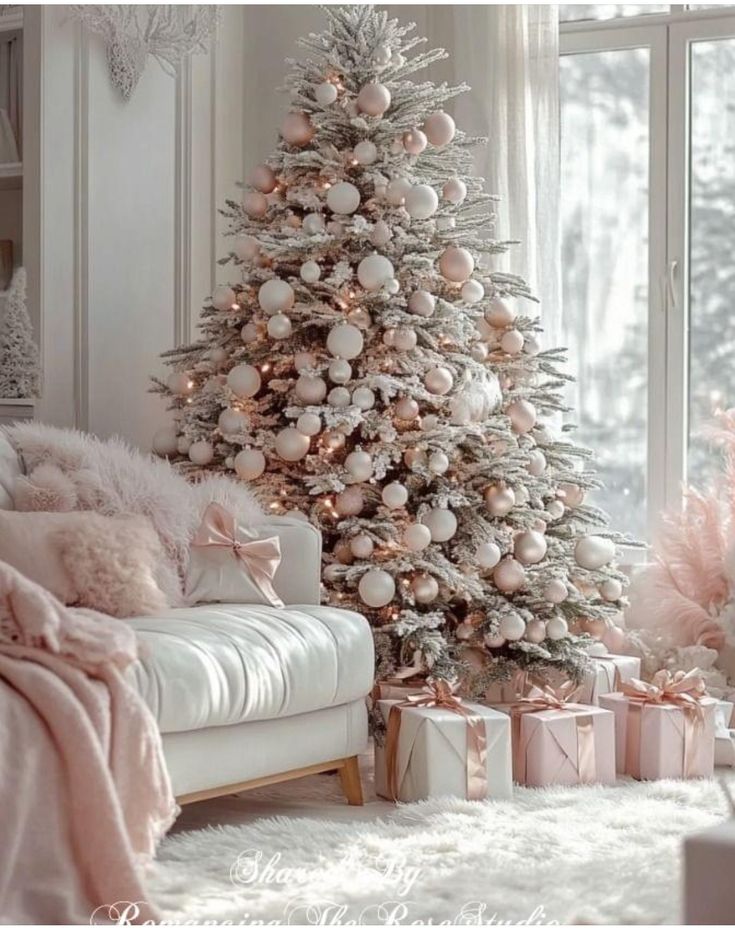 a white christmas tree with pink and silver ornaments