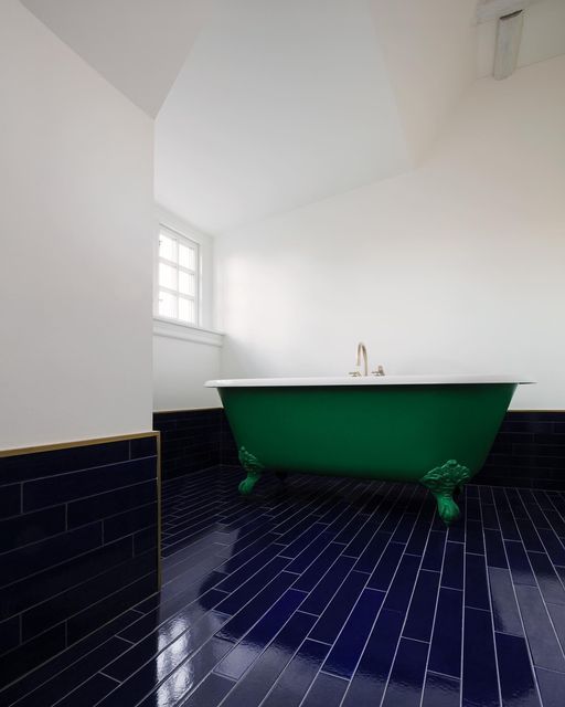 a green bath tub sitting inside of a bathroom