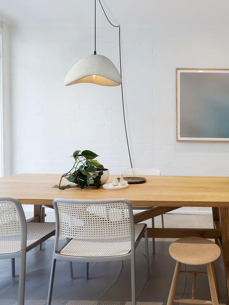 a dining room table with chairs and a potted plant on the table in front of it