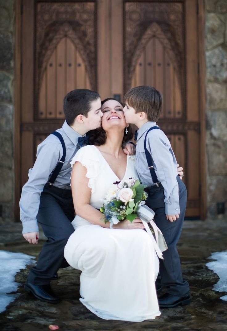 a bride and groom kissing in front of a church door