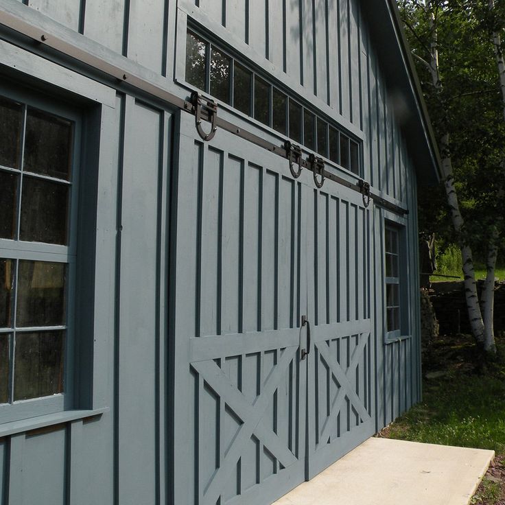 the side of a gray barn with blue windows