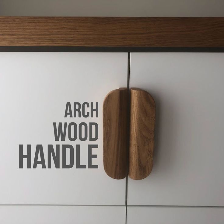 an arch wood handle is mounted on the side of a white cabinet with black lettering