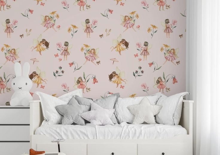 a white day bed sitting next to a pink wallpaper with fairy dolls on it