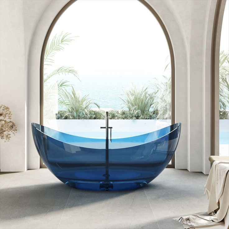 a large blue bath tub sitting under an arched window