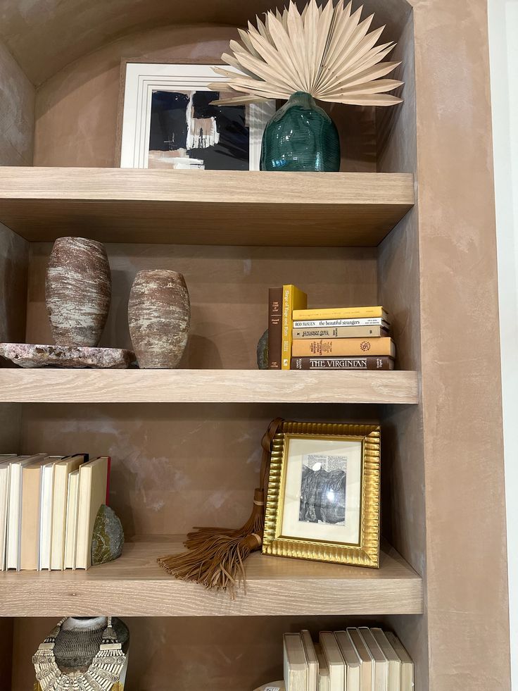 a book shelf filled with books and vases