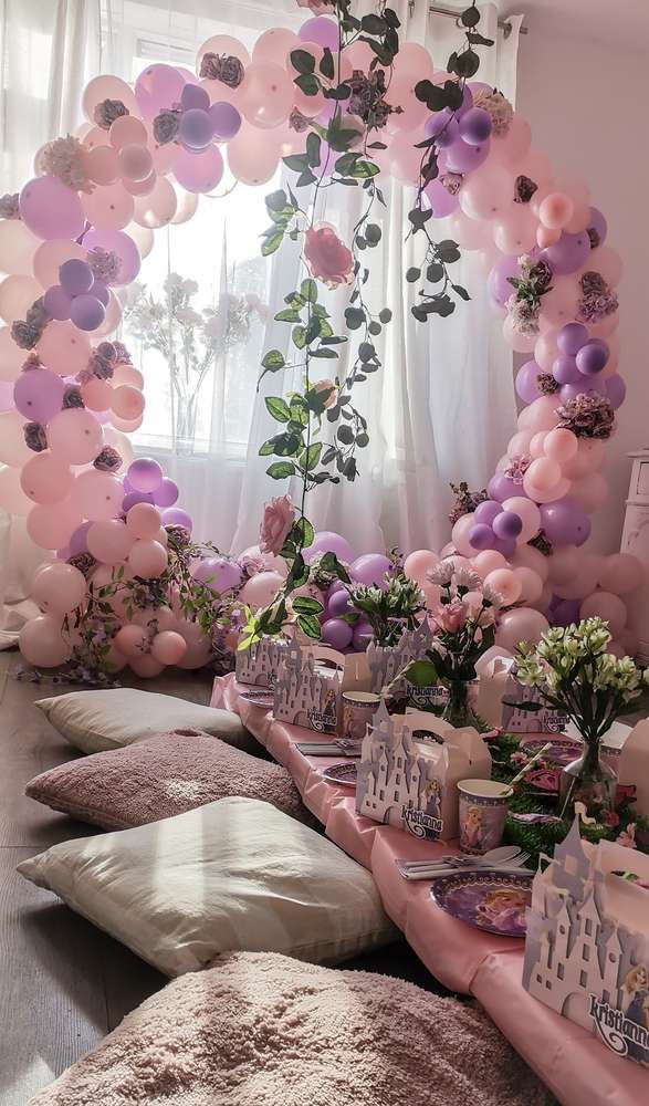 balloons and flowers are on the windowsill in front of a window with pink curtains