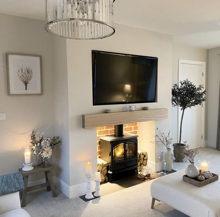 a living room filled with furniture and a flat screen tv mounted on the wall above a fire place