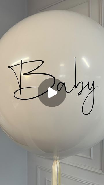 a white balloon with the word baby written on it's side and a black marker