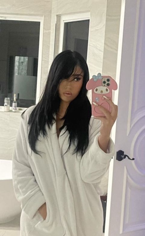 a woman taking a selfie in front of a mirror with a cell phone case