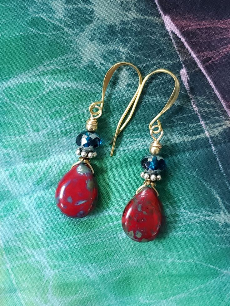 Dress up your denim with these earrings featuring a czech glass red teardrop with picasso wash, silver spacer and blue faceted glass bead.  Gold plated ear wires are nickel free and secured with silicone earring backs. Hypoallergenic Czech Glass Teardrop Earrings, Beaded Czech Glass Teardrop Earrings, Nickel Free Red Teardrop Earrings, Handmade Adjustable Red Teardrop Earrings, Adjustable Handmade Red Teardrop Earrings, Nickel-free Czech Glass Teardrop Earrings As Gift, Elegant Red Czech Glass Beaded Earrings, Adjustable Red Czech Glass Beaded Earrings, Red Nickel-free Teardrop Earrings