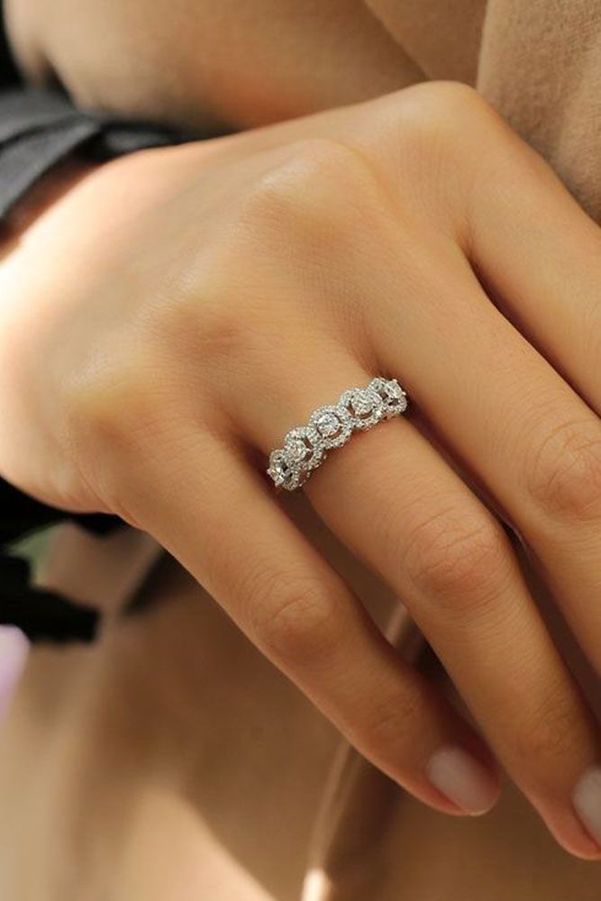 a woman's hand wearing a three stone diamond ring