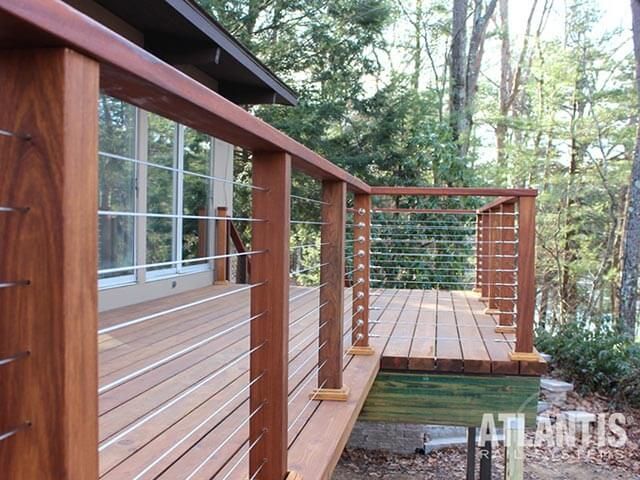 a wooden deck with railing next to a pond