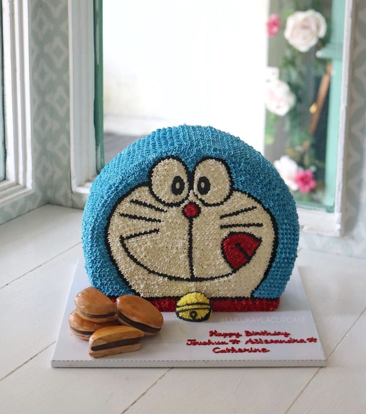 a cake made to look like a cartoon character sitting on top of a table next to some cookies