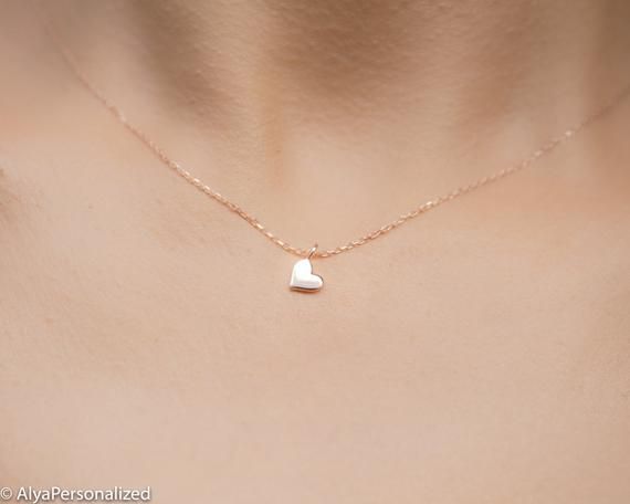 14k solid gold heart necklace;  a tiny heart! It is a wonderful gift for her which will be with her for a life time because of the real gold material...Elegant and minimalist  ♡► FEATURES;Material Options: 14K White Gold/ Rose Gold / Yellow GoldLength : Standart length is 16''+0.5'' extention chain (The necklace on the photo is also 16'' in length).❥ I can adjust necklace length to your demands, please add me a note during check out if you wish a different necklace length.► HOW TO ORDER;Please s Minimalist 14k Gold Heart Necklace For Anniversary, Dainty 14k Gold Charm Necklace For Anniversary, Tiny Simple Charm Necklace As Gift, Dainty Charm Necklaces With Simple Design For Gifts, Simple Tiny Charm Necklaces For Gifts, Simple Tiny Charm Necklaces As Gift, Simple Tiny Charm Necklace For Gift, Minimalist Heart Cut Charm Necklace As Gift, Minimalist Heart Charm Necklace For Anniversary Gift