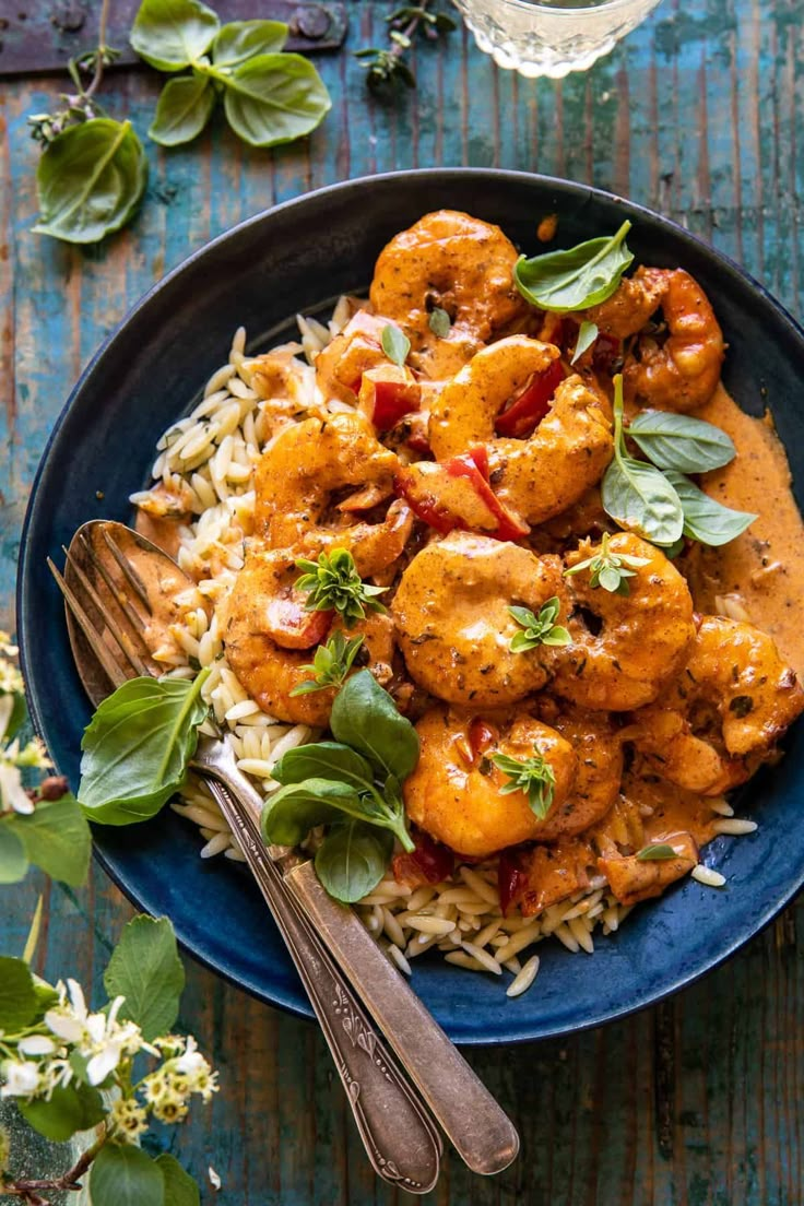 a blue plate topped with shrimp and rice