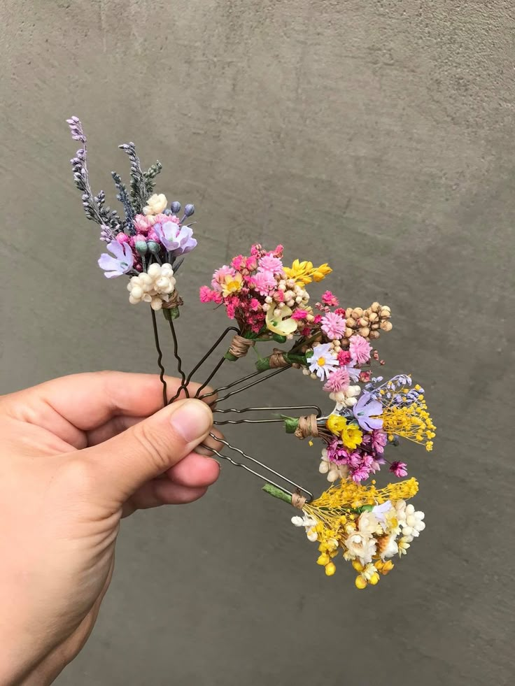 a person is holding flowers in their hand