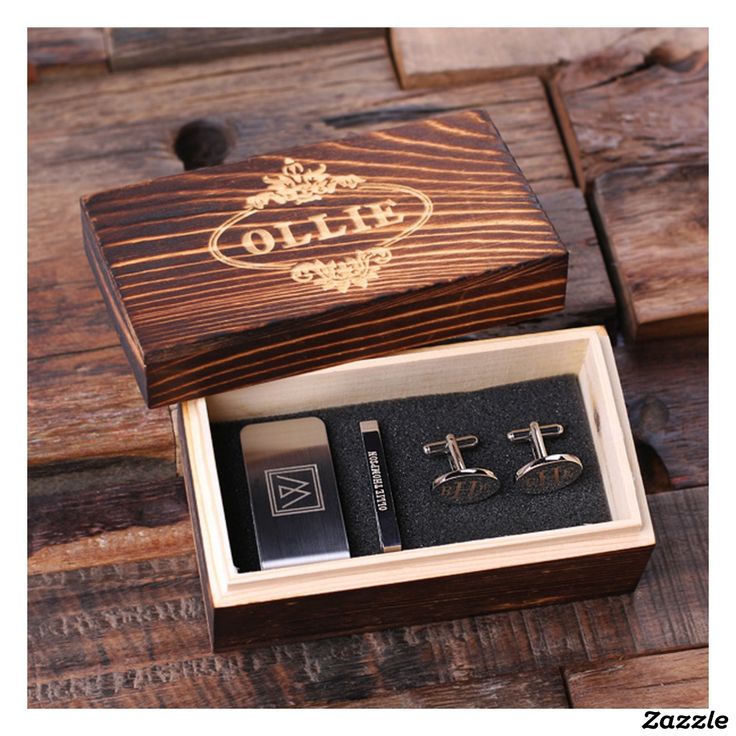 two pairs of cufflinks in a box on a wooden table with other items