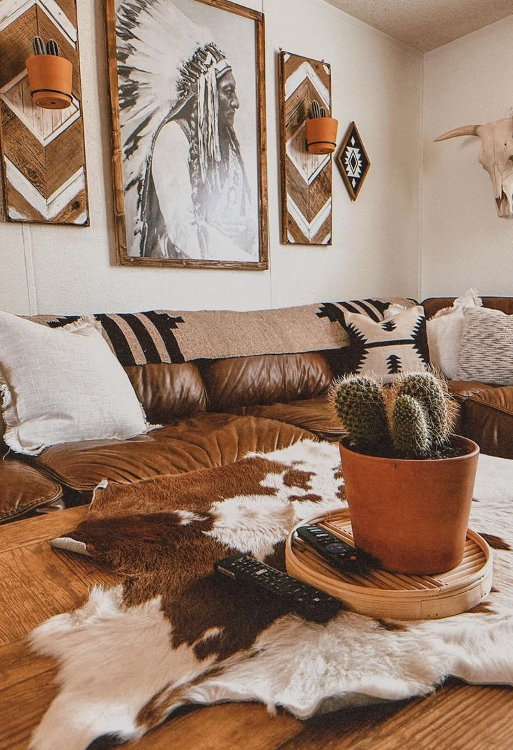 a living room with leather couches, cow hide rug and pictures on the wall