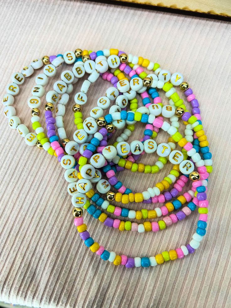 Spruce up your spring wardrobe with a colorful, seed bead bracelet. Each one features Easter-inspired words like "Bunny" "Spring" "Happy Easter" "Faith". Perfect for adding a touch of fun and whimsy to your outfit. (Egg-cellent for Easter!)These are sent at random but you may request what you want in the notes checkout! Easter Seed Bead Bracelet, Spring Beach Bracelets With Letter Beads, Casual Letter Beads Friendship Bracelets For Spring, Everyday Beaded Bracelets For Spring, Casual Tiny Beads Bracelet For Spring, Beaded Bracelets For Everyday Spring Wear, Casual Tiny Beads Bracelets For Spring, Bohemian Stretch Bracelet With Colorful Beads For Spring, Colorful Bohemian Beaded Bracelets For Spring