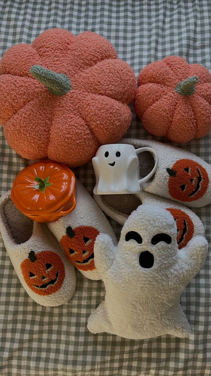 several stuffed animals and pumpkins on a bed